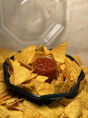 Produktabbildung: schwarze Plastikschale mit Tortillas und Becher mit Salsa Soße, auf einem Haufen Tortillas.